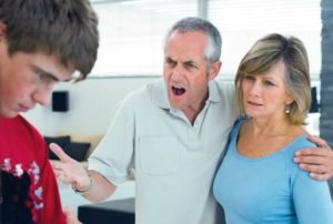 dad yelling at his son with wife at his side