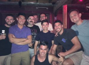 group of men smiling in a bar