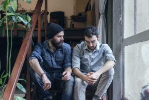 two men sitting on stairs in deep conversation