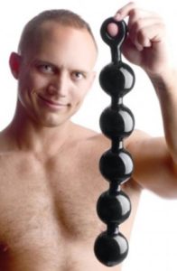 shirtless man holding up big black anal beads